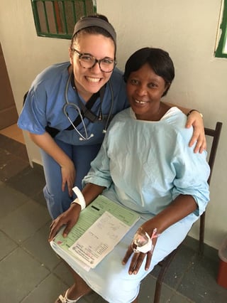 Alex Boulton, a sophomore nursing student at Nebraska Methodist College, poses with a Haitian woman after placing an IV in her hand.