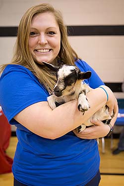 NMC nursing student holds baby goat at the Minne Lusa Health Carnival.