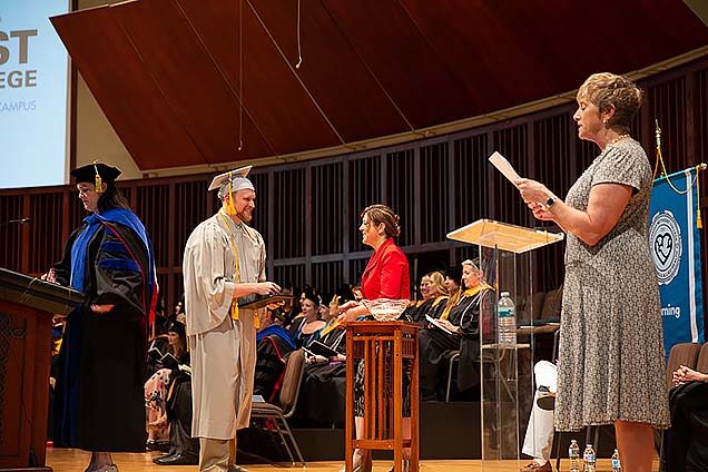 A student receives his diploma at graduation.