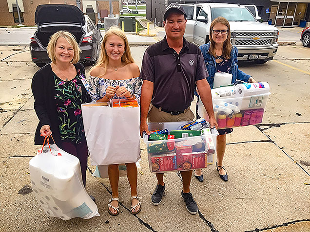 Megan Jacobsen, her parents, and Director of Student Support Services Lisa Johnson bring the items from Megan's food drive into the NMC Food Pantry.