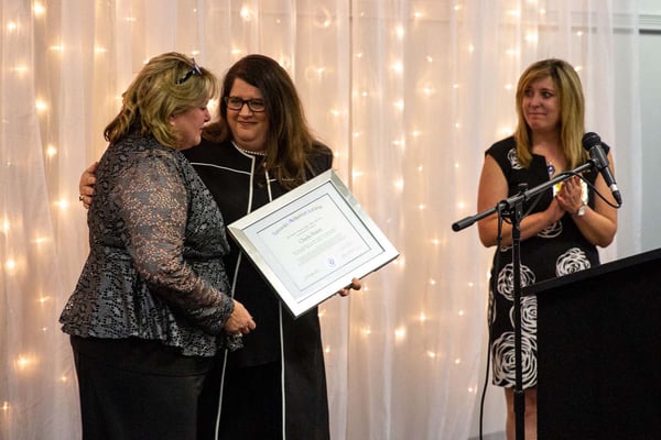 Stephanie Pettett receives honorary diploma in Cheyla's name from Michelle Massey, with Angela Heesacker Smith at right.