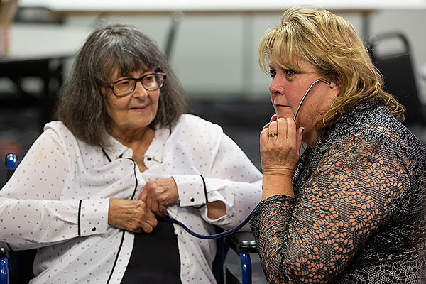 Heart recipient Jan Going positions stethoscope so Stephanie Pettett can listen to Cheyla’s heart beating.