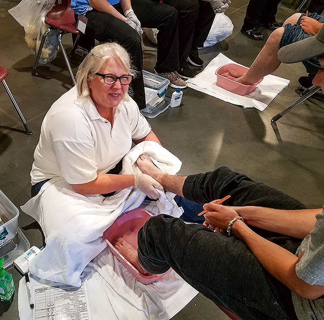 NMC nursing student Lisa Kessler examines a client's foot.
