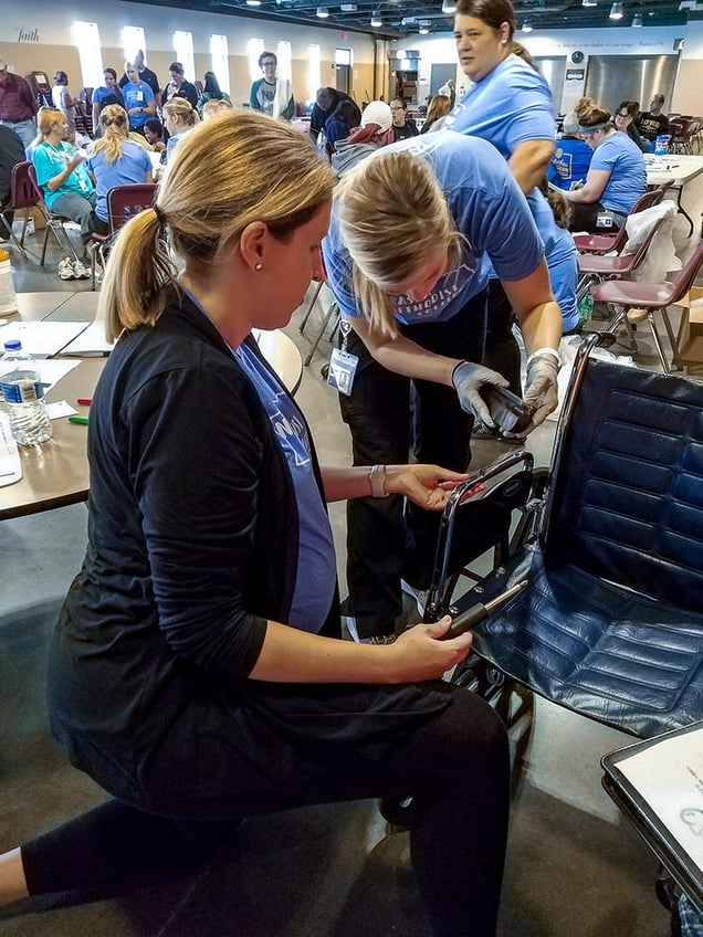 MOT Program Director Melissa Kimmerling, EdD, OTR/L, and student Erin Shuck make wheelchair adjustments.