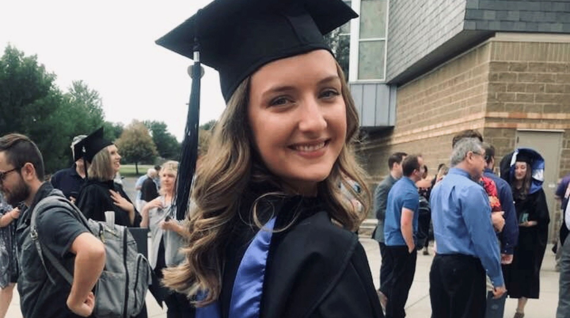 Nebraska Methodist College alumna Andrea Tesarek smiles while wearing her graduation gown and cap after graduating with a master's in occupational therapy.
