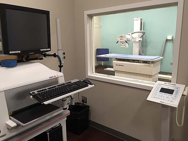The Rad Tech Lab in the 501 building featuring a mock patient room with screening equipment and an observation room with a computer and rad tech equipment