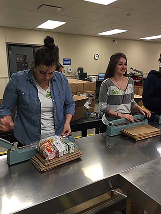 NMC students packaging up backpacks with nutritious food items
