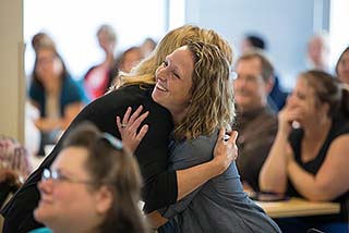 Kara Meisinger embracing NMC's president, Deb Carlson