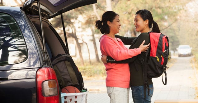 Mother and daughter hug as they move her into the dorms