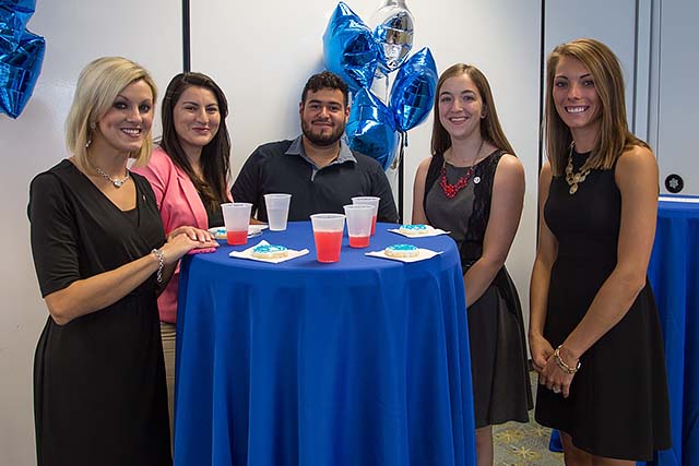 Occupational therapy students standing around a table with cookies and punch