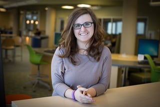 Sajna sitting in the NMC library, smiling for the camera