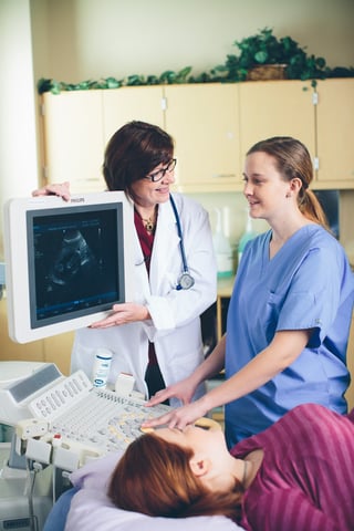 Sonographer performing a sonogram on a pregnant woman