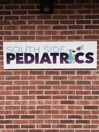 A brick wall with a sign reading "South Side Pediatrics"