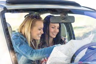 Two Traveling Students looking at a map while on a road trip