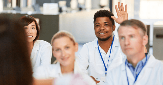 Class of nursing students with one student raising his hand