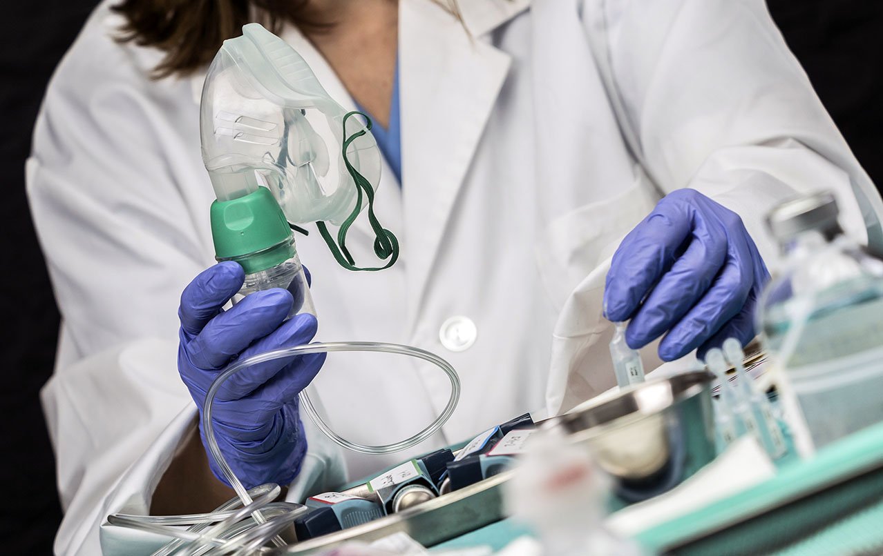 Respiratory therapist holding a breathing mask hooked up to a thin clear tube