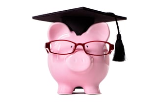 A piggy bank wearing a graduation cap and wearing glasses