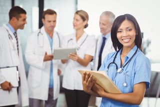 Healthcare Leaders - Nurses and doctors standing together discussing patient charts