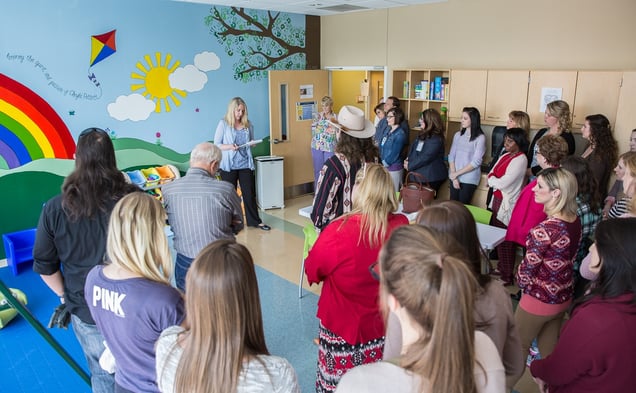 Ceremony unveiling the mural honoring Cheyla Pettett in the pediatrics lab. The mural is of a blue sky, rolling hills, a rainbow, some clouds, the sun and a kite