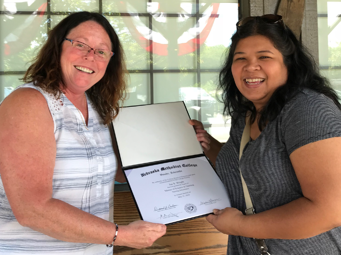 NMC Informatics Director Debborah “Debb” Adams presents MSN diploma to new graduate Jae Wright in Crown Point, Indiana.