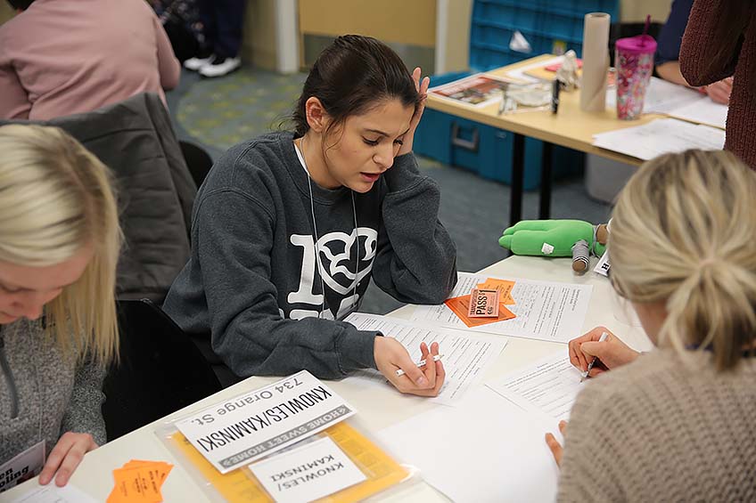 A student fills out an application for benefits and assistance for her "family" during the poverty simulation.