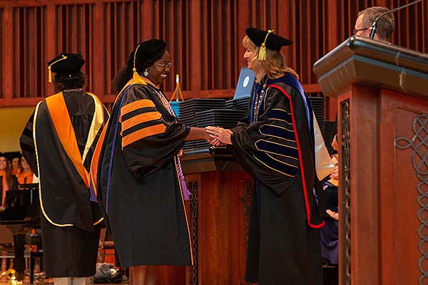 Image of Dr. Deb Carlson congratulating a DNP graduate.