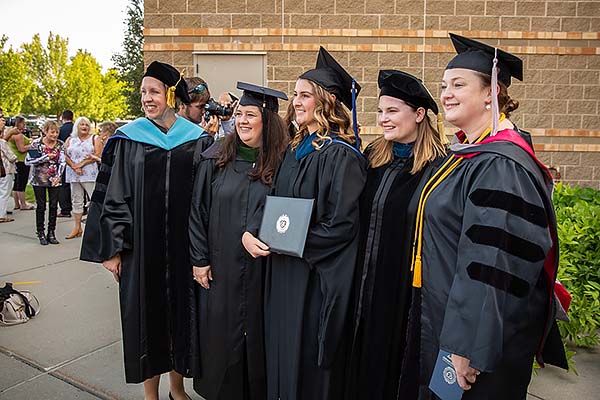 Image of an MOT graduate with faculty members