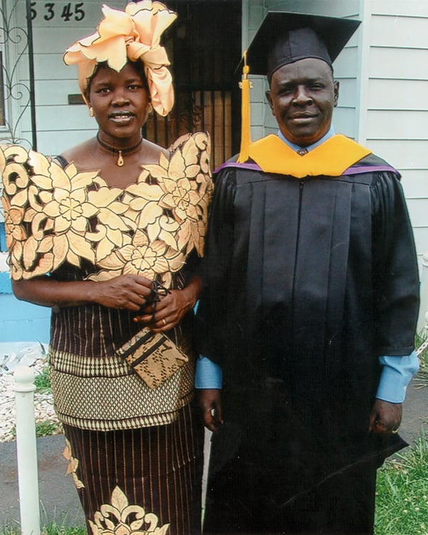 Anna Michael, poses in formal dress and headscarf, with husband, in graduation cap and gown, after he received his Master's degree from Bellevue University.