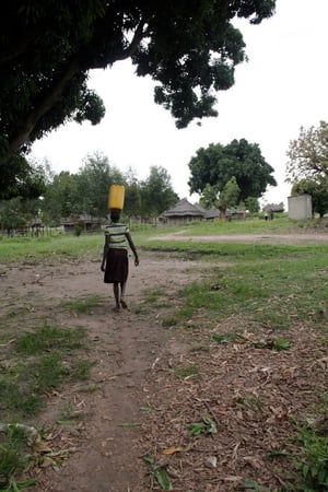 A villager carries water back to their home.