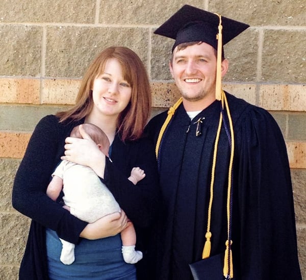Troy Beekman, in cap and gown, at 2014 graduation with wife, Janelle, and their first child, Eleanor.