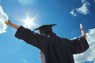 A occupational therapy graduate in their cap and gown holding their good occupational therapy degree