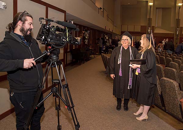 KMTV Channel 3 news reporter focuses videocamera on Lisa and Cassandra for a post-graduation interview.