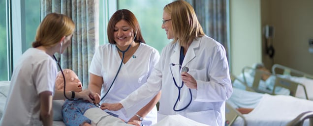 Nebraska Methodist College nursing students performing an exam on a child dummy in a realistic hospital room and bed.The NMC Nursing Arts Center is a high-tech simulation lab that gives students the practice and confidence needed to provide patient care in the clinical setting.