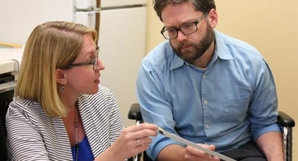 An occupational therapist working with a man in a wheelchair