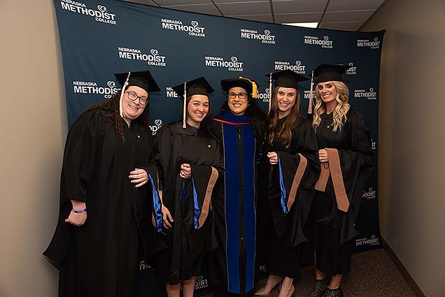 A group of students pose with Dr. Whitney Robertson before the ceremony.